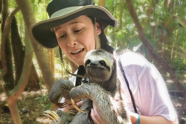 A woman holding a sloth.